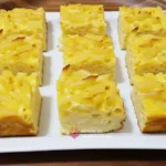 Budincă de paste cu brânză de vaci preparată și servită pe o farfurie