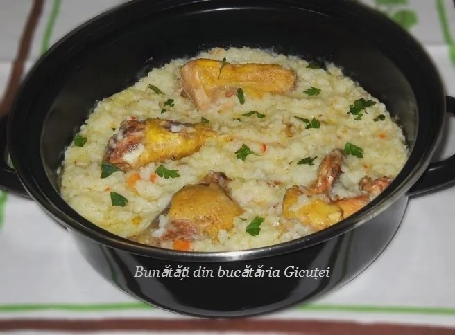 Pilaf cu carne de pasăre servit pe un platou cu garnitură de legume proaspete.